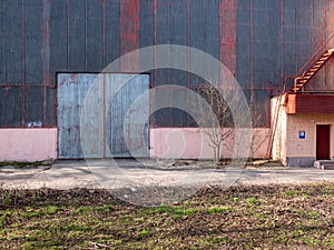 Aged angar facade with high groove metal gateway