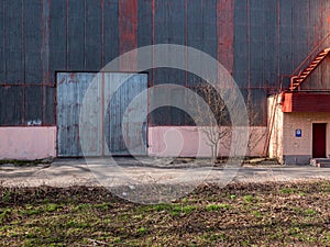 Aged angar facade with high groove metal gateway