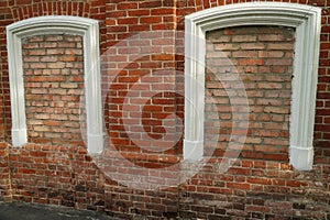 Aged brick wall with four arched bricked up windows with space for text