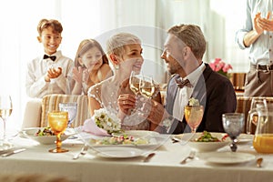 Aged bridge and groom clanging their glasses with champagne