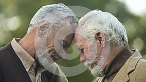 Aged brothers touching heads, family connection, friendship support, buddy