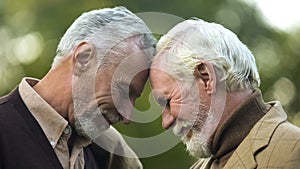 Aged brothers touching heads, family connection, friendship support, buddy