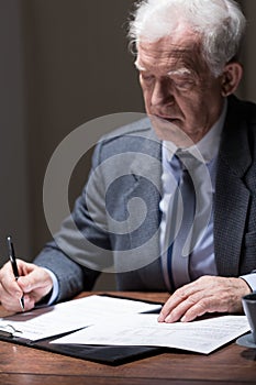 Aged businessman doing paperwork