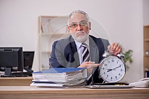 Aged businessman employee in time management concept