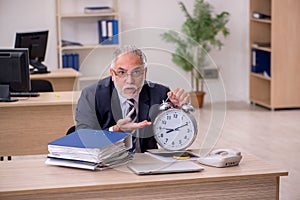 Aged businessman employee in time management concept