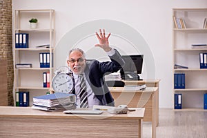 Aged businessman employee in time management concept