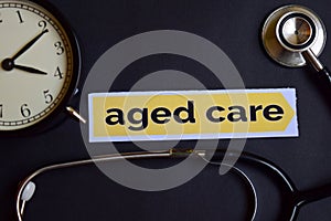 Aged care on the print paper with Healthcare Concept Inspiration. alarm clock, Black stethoscope.