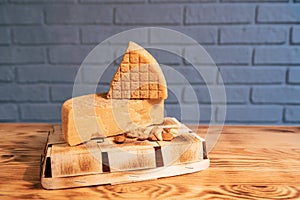 Aged cheese and nuts on a wooden table against a brick wall