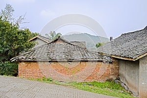 Aged Chinese farmhouses by slopy countryroad in sunny spring