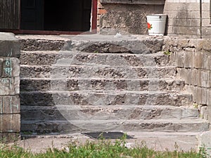 Aged concrete entrance steps of the porch