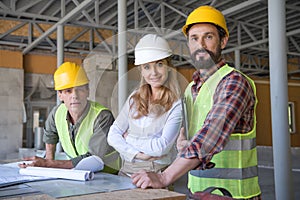 Aged constructors and contractor looking at camera during work on construction site