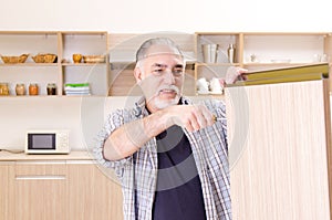 The aged contractor repairman working in the kitchen