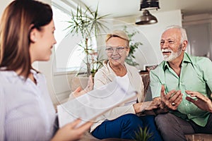 Aged couple consulting with insurance agent