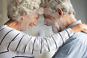 Aged couple looking at each other touching with foreheads