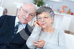 Aged couple sharing headphones listening to radio