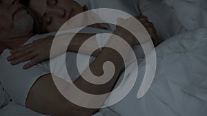 Aged couple sleeping in bed, woman lying on man chest, tender relationship, love