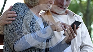 Aged couple using modern smartphone, lack of skills, difficult technologies