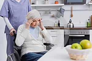 aged disabled woman touching head while