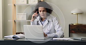 Aged female doctor gp consult patient by phone using laptop