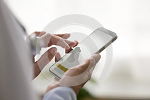 Aged female general practitioner holding modern smart phone in hands