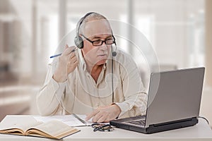 Aged freelance male tutor working online photo