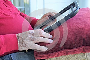 Aged gentleman listens through earbuds and reads device