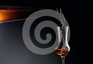 Aged golden fortified wine from the antique bottle being poured into a crystal glass
