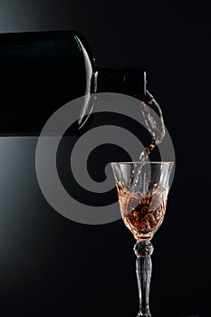 Aged golden fortified wine from the antique bottle being poured into a crystal glass