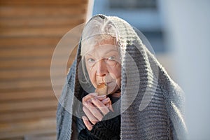 Aged homeless woman eating little cracker