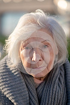 Aged homeless woman with facial wrinkles feeling unprotected