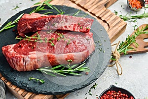 Aged juicy striploin steak. Meat. On a black stone background.