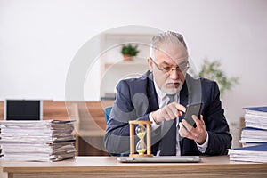 Aged male employee in time management concept