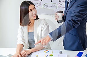 Aged male mentor boss looking at computer screen happy for achievement and good online work result of young female intern, senior