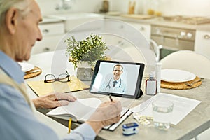 Aged man consulting medical specialist online from home