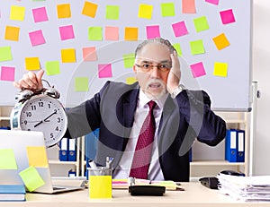 Aged man employee in conflicting priorities concept