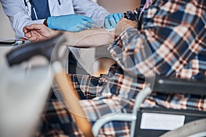 Aged man getting an insulin shot into the arm