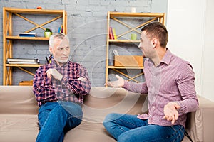 Aged man giving advice to his adult son