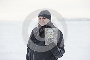 Aged man with his photo as child