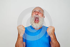 Aged man screaming in fury with clenched fists against white background