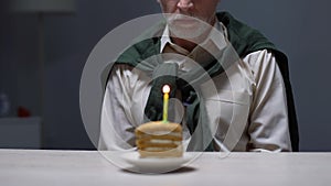 Aged man sitting alone with birthday cake, abandoned by relatives, problems