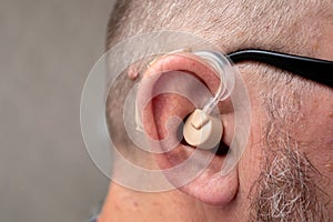 Aged man wearing modern digital hearing aid