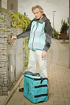 Aged man working as digital platform food delivery in duty on street