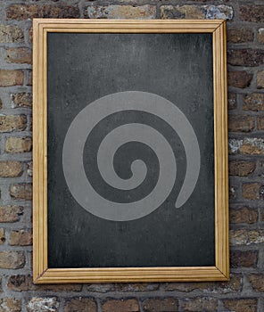 Aged menu blackboard hanging on brick wall