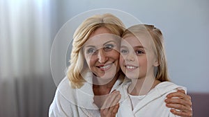 Aged mother hugging her long-awaited daughter and looking in mirror, family photo