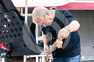 Aged musician tuning his electric guitar on stage