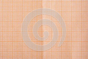 Aged old grunge grid millimeter paper background. Close up of orange sepia graph paper texture.