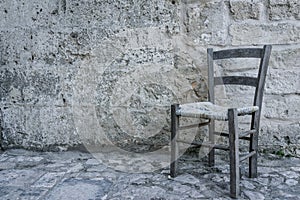 Aged old traditional chair in empty stone room in ancient ghost