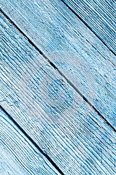 Aged painted cracked boards with blue color peeling paint. Old natural grunge textured wooden texture. Weathered wood wall for