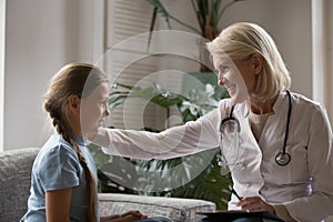 Aged pediatrician communicating with little patient stroke her showing caress photo