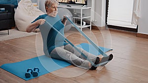 Aged person using elastic resistance band to exercise